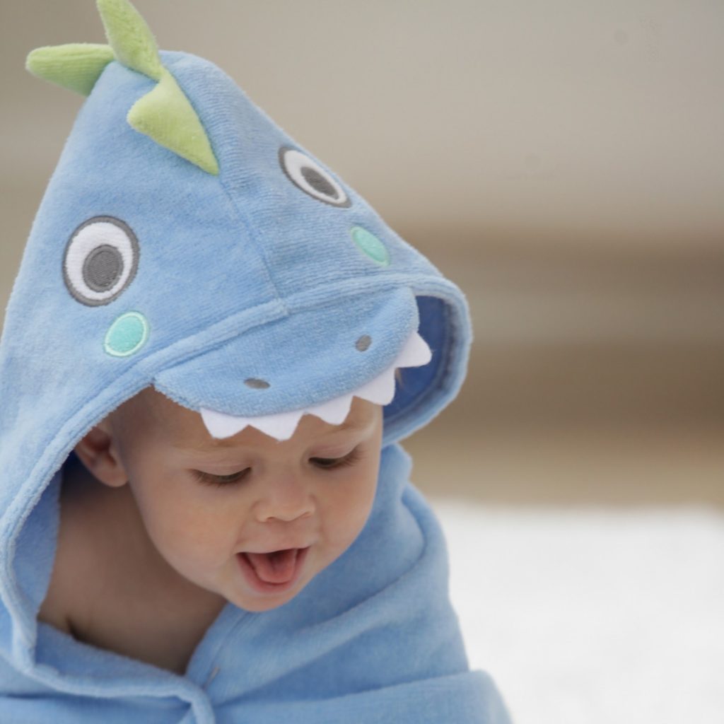 A child having fun after a bath with his sea serpent hooded bath towel