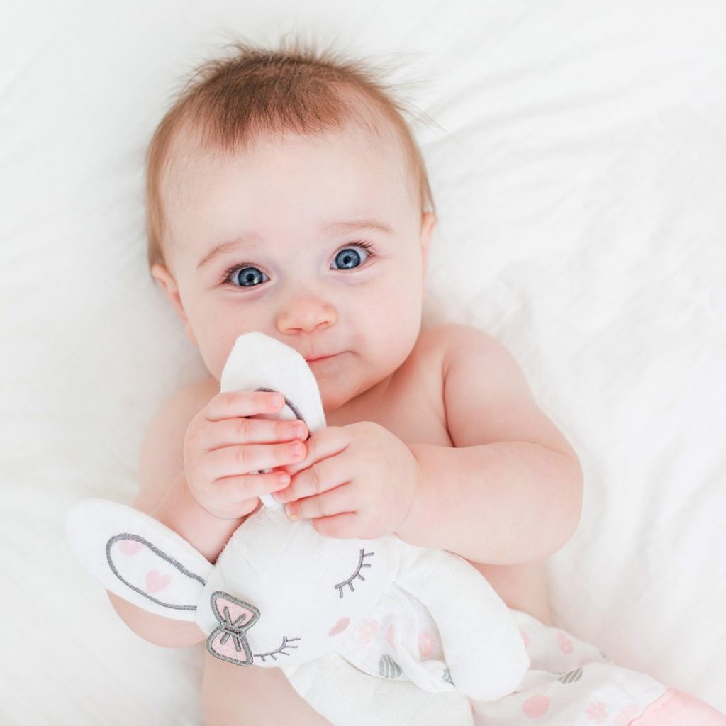 An adorable child holding the Lulujo pink bunny baby lovie security blanket