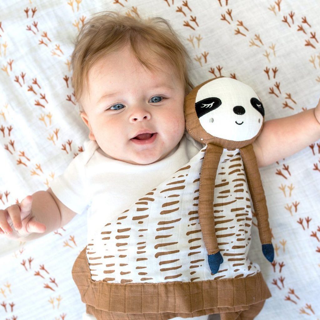 A cute child playing with the sloth security blanket for babies, made by Lulujo