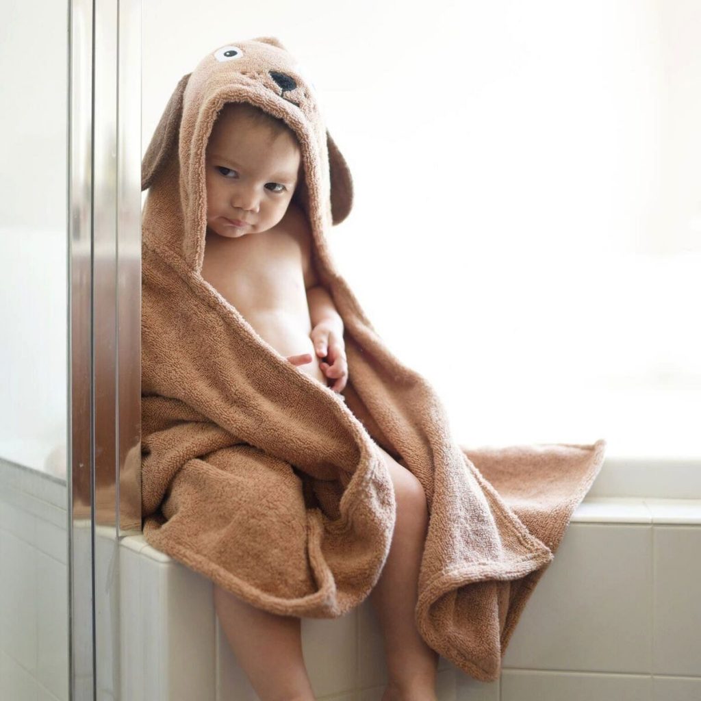 A child being cool wearing the dog hooded towel for kids, made by Yikes Twins